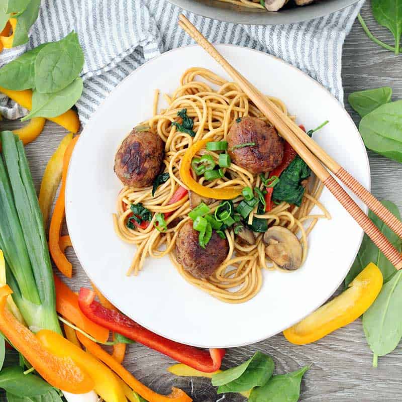 Square photo of an overhead shot of meatball lo mein on a plate.