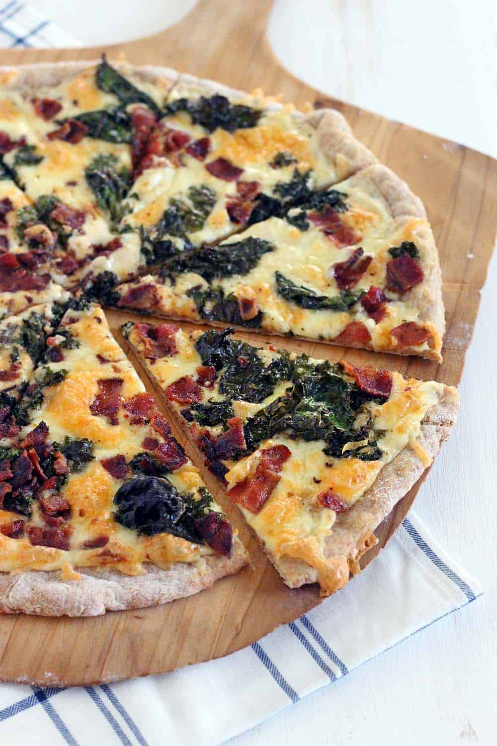 This Bacon and Kale Pizza is topped with super crispy kale and bacon pieces. This recipe comes together with only 5 ingredients in under 30 minutes!