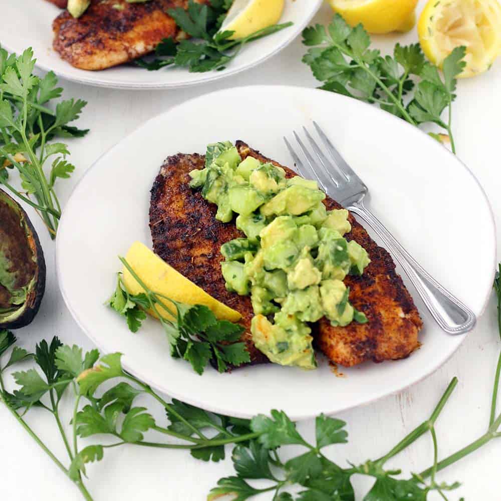 This super flavorful Blackened Tilapia comes together in less than 10 minutes!! Topped with a cool and refreshing avocado cucumber salsa, this is the perfect quick and easy low-carb recipe. Paleo, gluten free, and whole30 compliant.