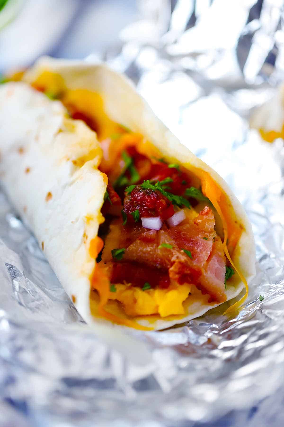 Close up photo of a breakfast taco in a soft flour tortilla.