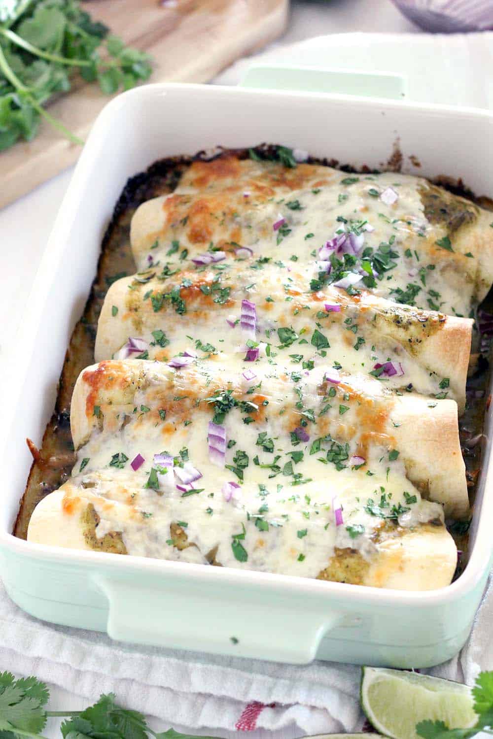 These Chicken and Spinach Enchiladas Verdes are my FAVORITE enchiladas! The recipe is freezable and packed with healthy greens, the chicken is marinated in a delicious jalape&ntilde;o garlic mixture, and they're topped with jarred roasted tomatillo salsa for a quick and easy shortcut.