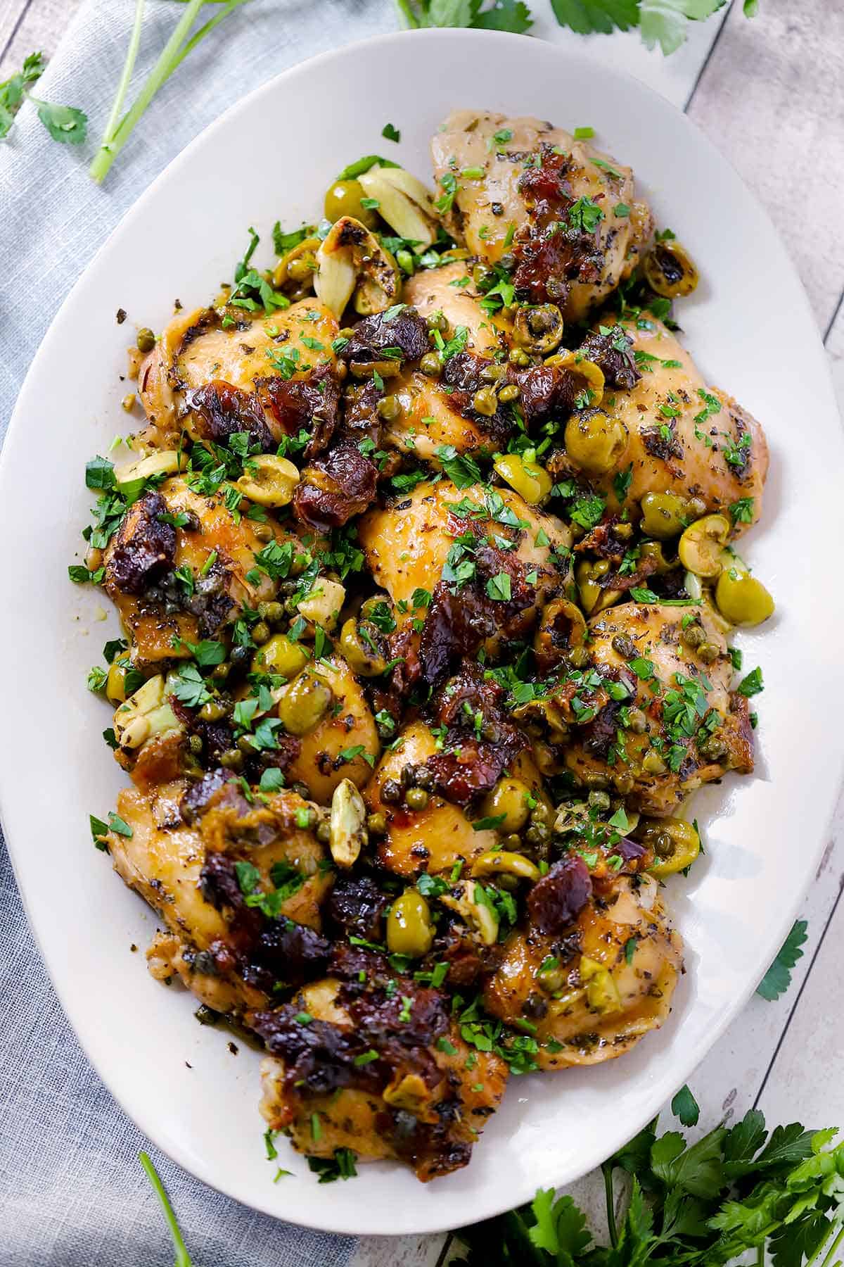 Overhead photo of Chicken Marbella on a white platter.