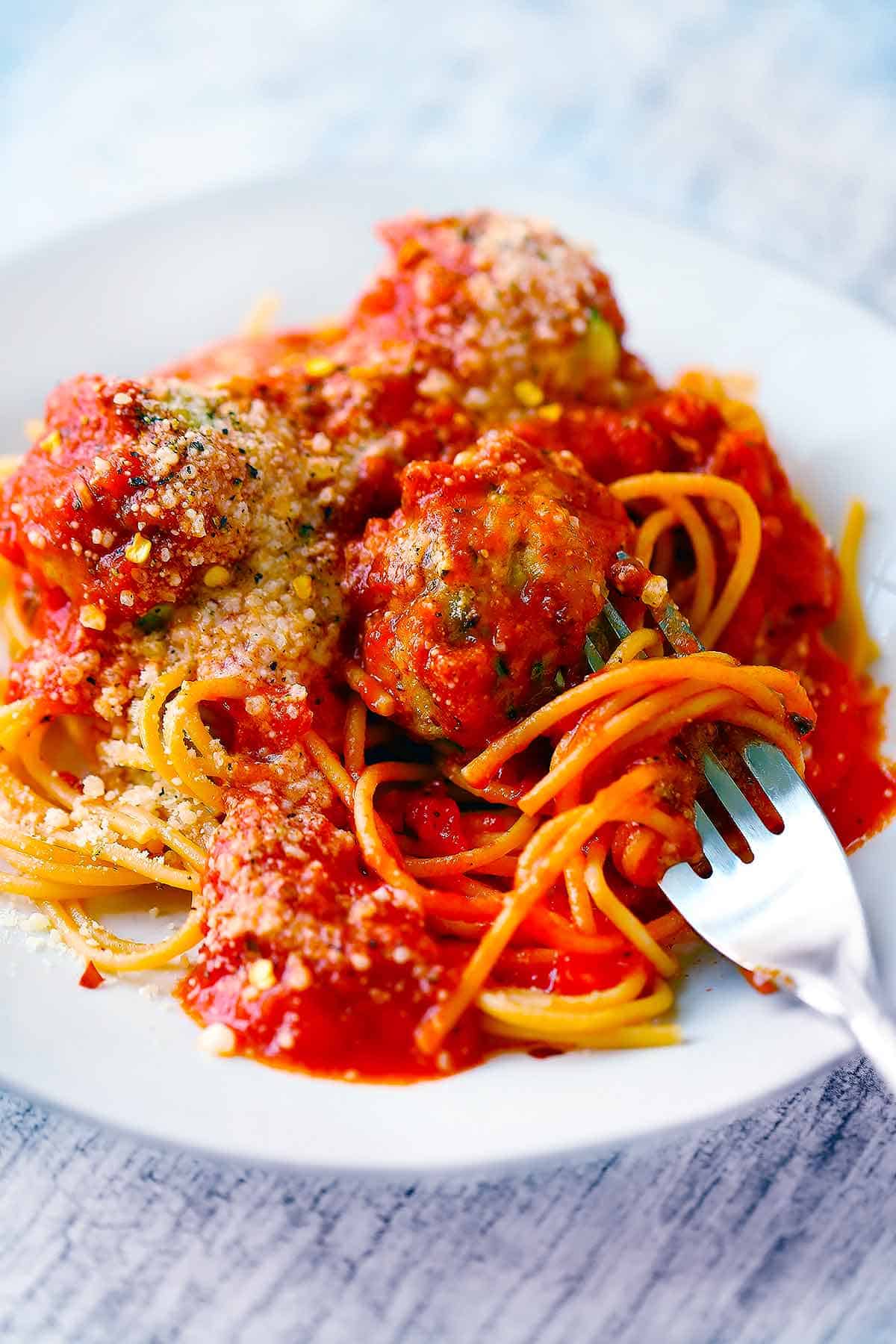 Spaghetti with chicken zucchini meatballs twirled with a fork.