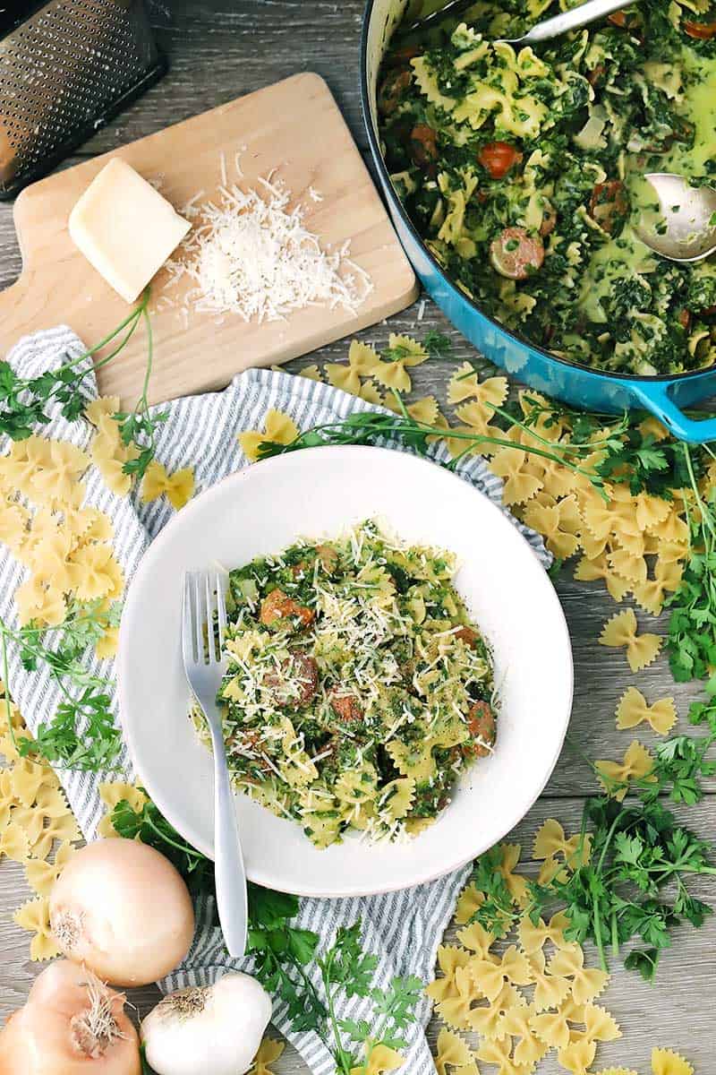 A white plate with pasta and ingredients around it.