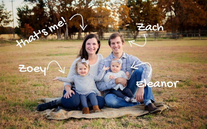 A mom, dad, and two daughters sitting on the ground