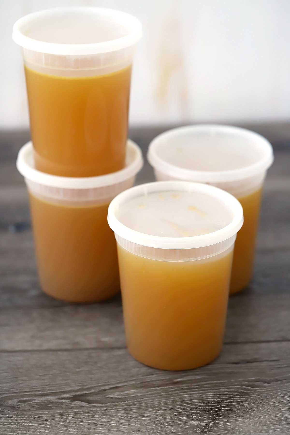 Four containers of homemade chicken stock