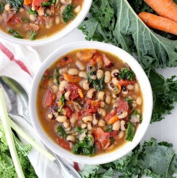 Overhead photo of two bowls of instant pot black eyed pea soup with kale and carrots.