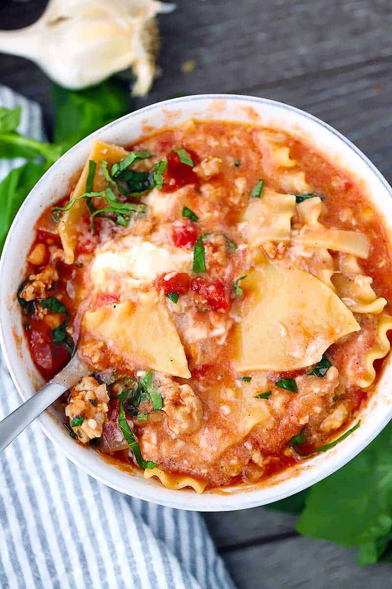 Overhead photo of a bowl of lasagna soup with a spoon in it.