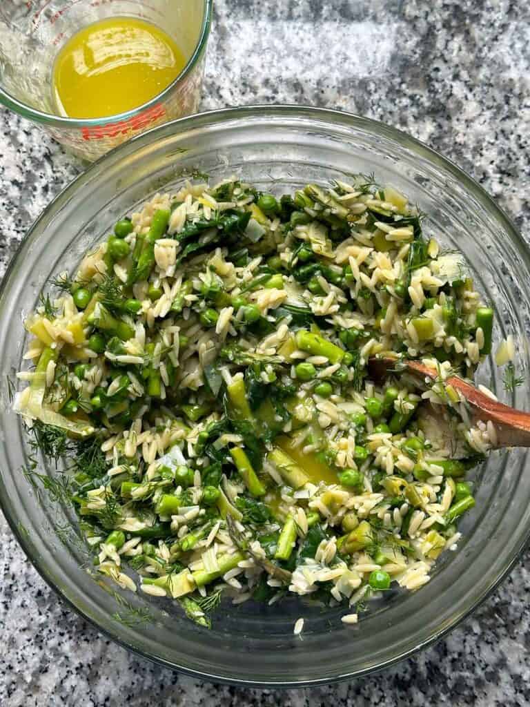 Adding a lemon garlic olive oil dressing to orzo with spring veggies and herbs.
