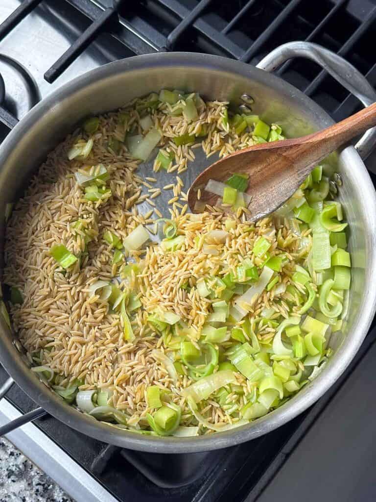 Toasting orzo with leeks in olive oil.