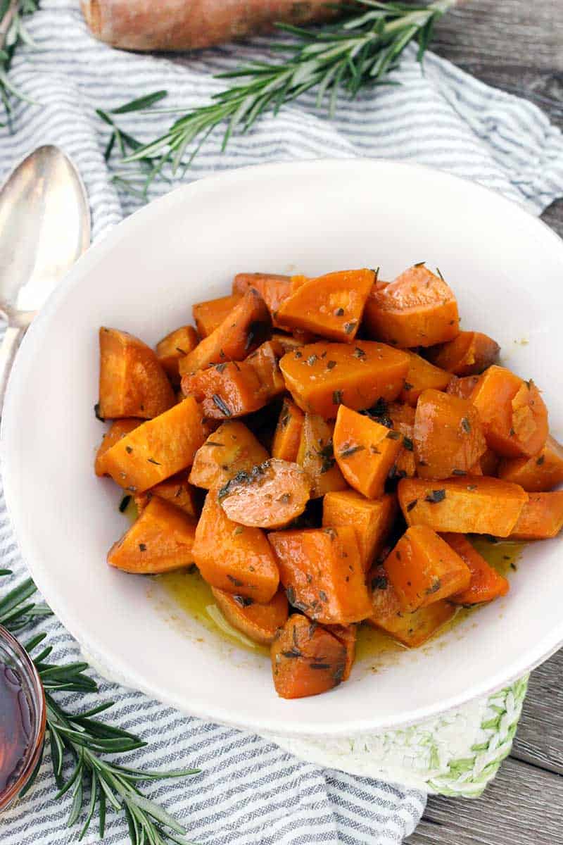 These Glazed Sweet Potatoes are coated in a mixture of melted butter, fresh rosemary, and maple syrup, then baked in the oven until super tender. They're not too sweet, and they're the perfect vegetarian, gluten-free side dish!