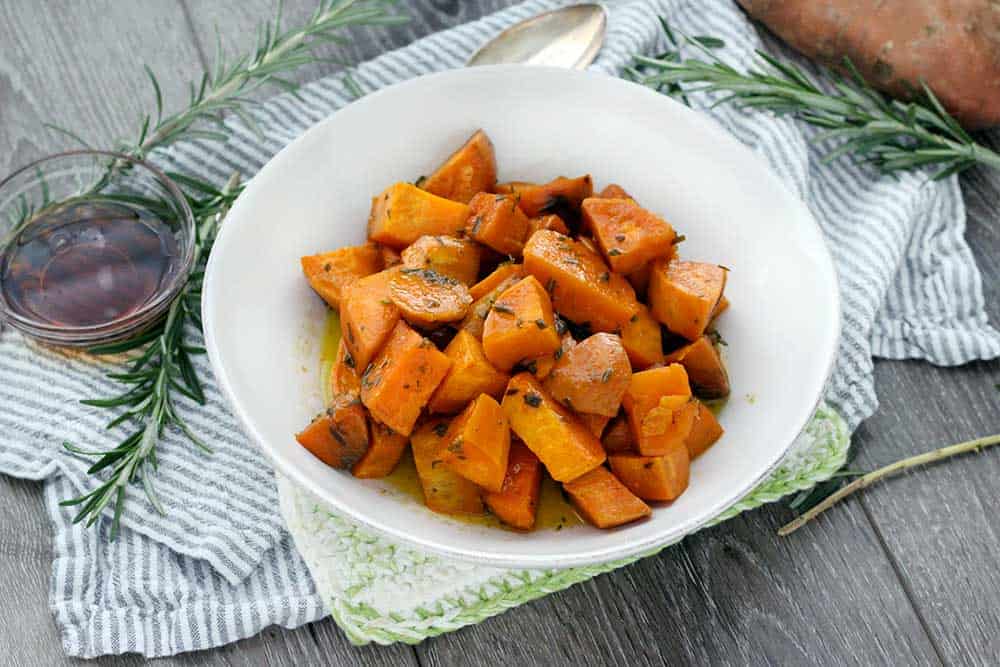 These Glazed Sweet Potatoes are coated in a mixture of melted butter, fresh rosemary, and maple syrup, then baked in the oven until super tender. They're not too sweet, and they're the perfect vegetarian, gluten-free side dish!
