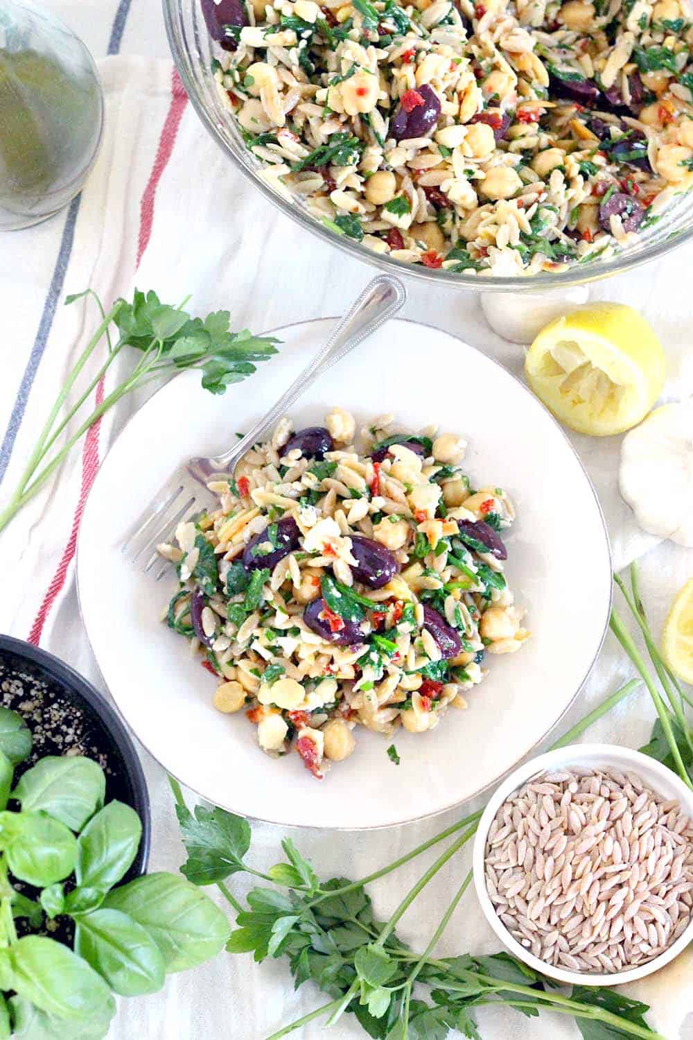 This easy Chickpea and Orzo Salad recipe has all the flavors of the Mediterranean- olives, feta, sun dried tomatoes, and garlic- with an awesome crunch from toasted almonds. It's packed with fiber and nutrients and is great as a side at a potluck or an entire meal.