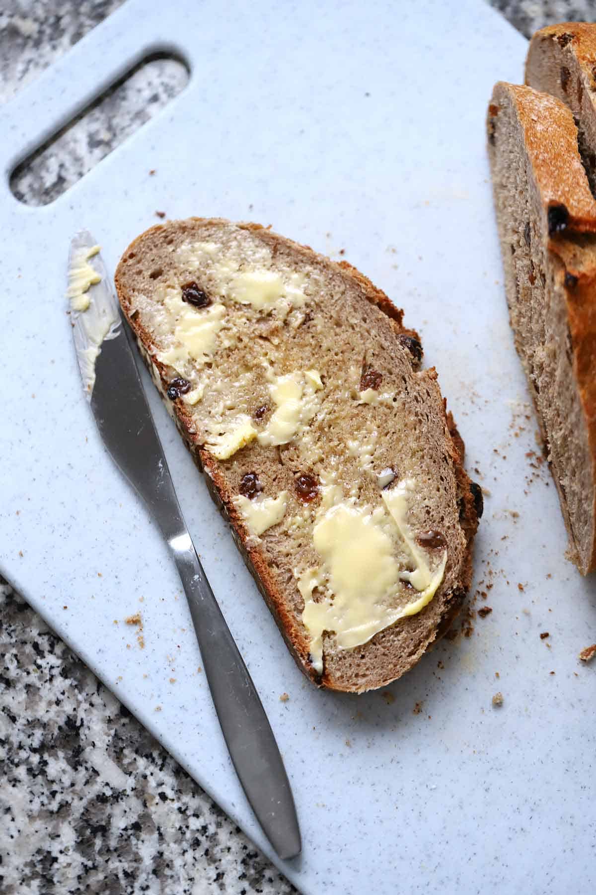 A buttered piece of cinnamon raisin bread.