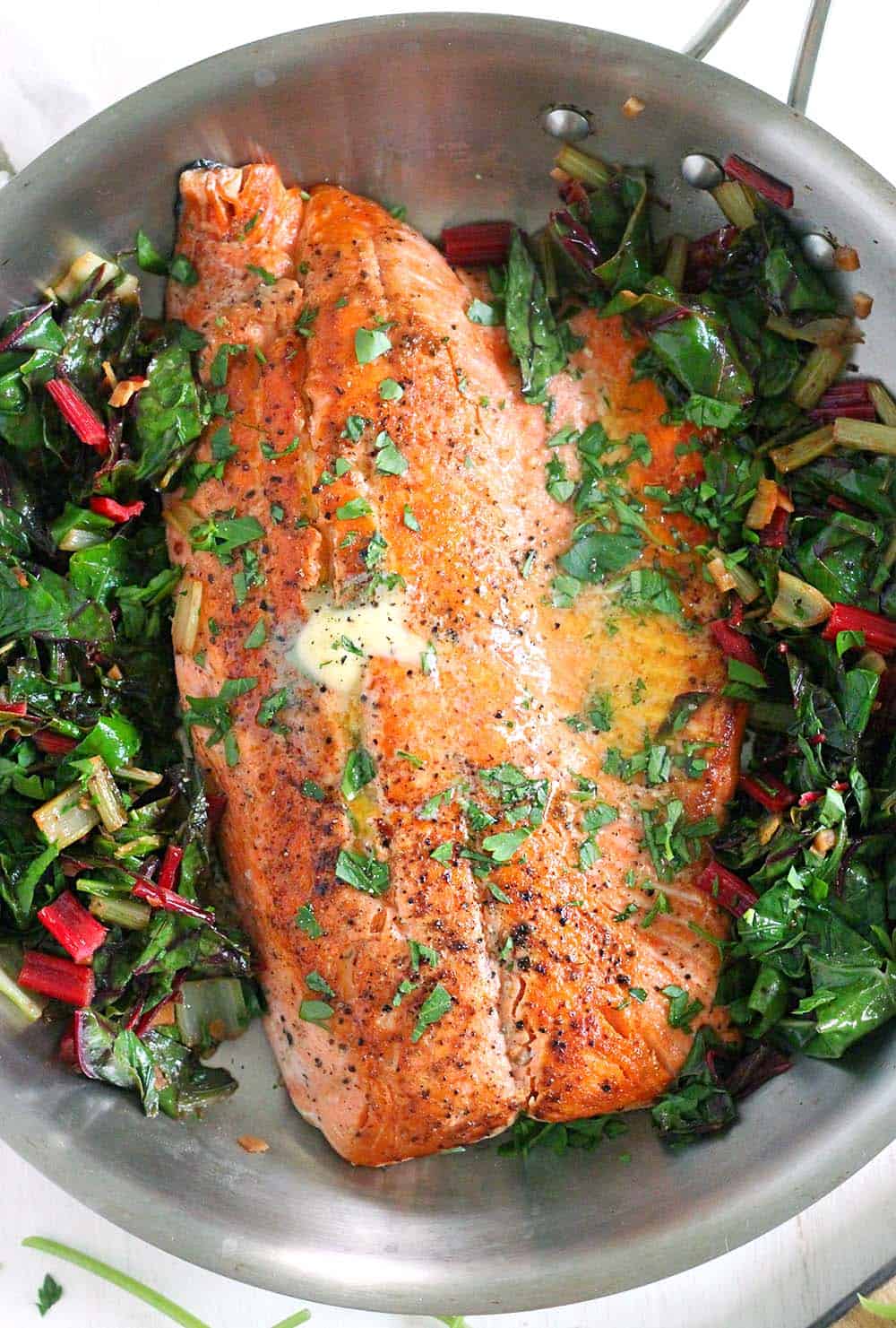 One Pan Garlic Butter Salmon and Swiss Chard- This healthy, gluten-free, low-carb recipe comes together in only 20 minutes! Can easily be made paleo or whole30 compliant by using ghee instead of butter.