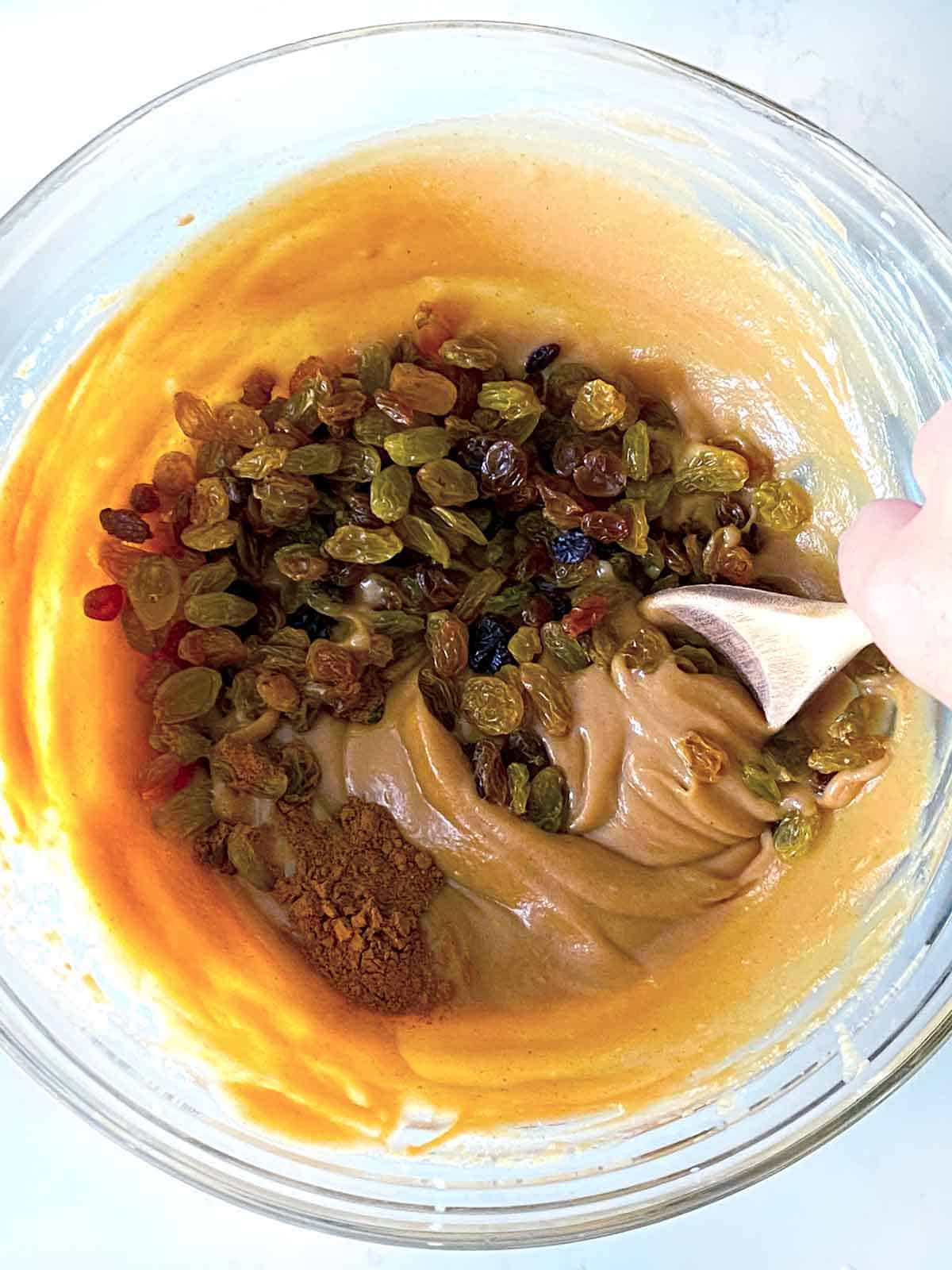 Mixing peanut butter dip with cinnamon and apples in a bowl.