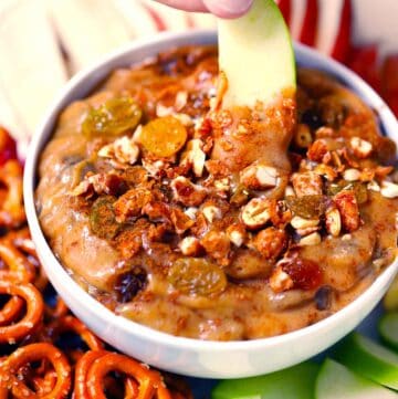 Square photo of an apple slice dipped in peanut butter dip.