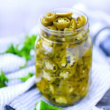 Square photo of pickled jalapeños in a mason jar.