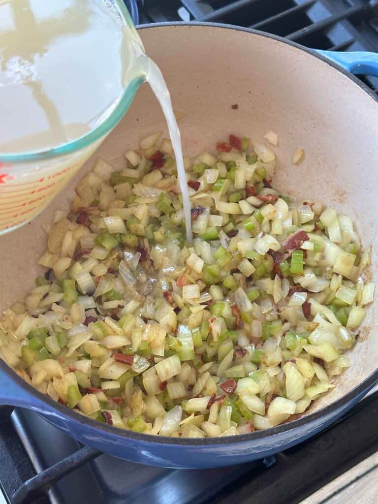 Pouring clam juice into a pot to make chowder.