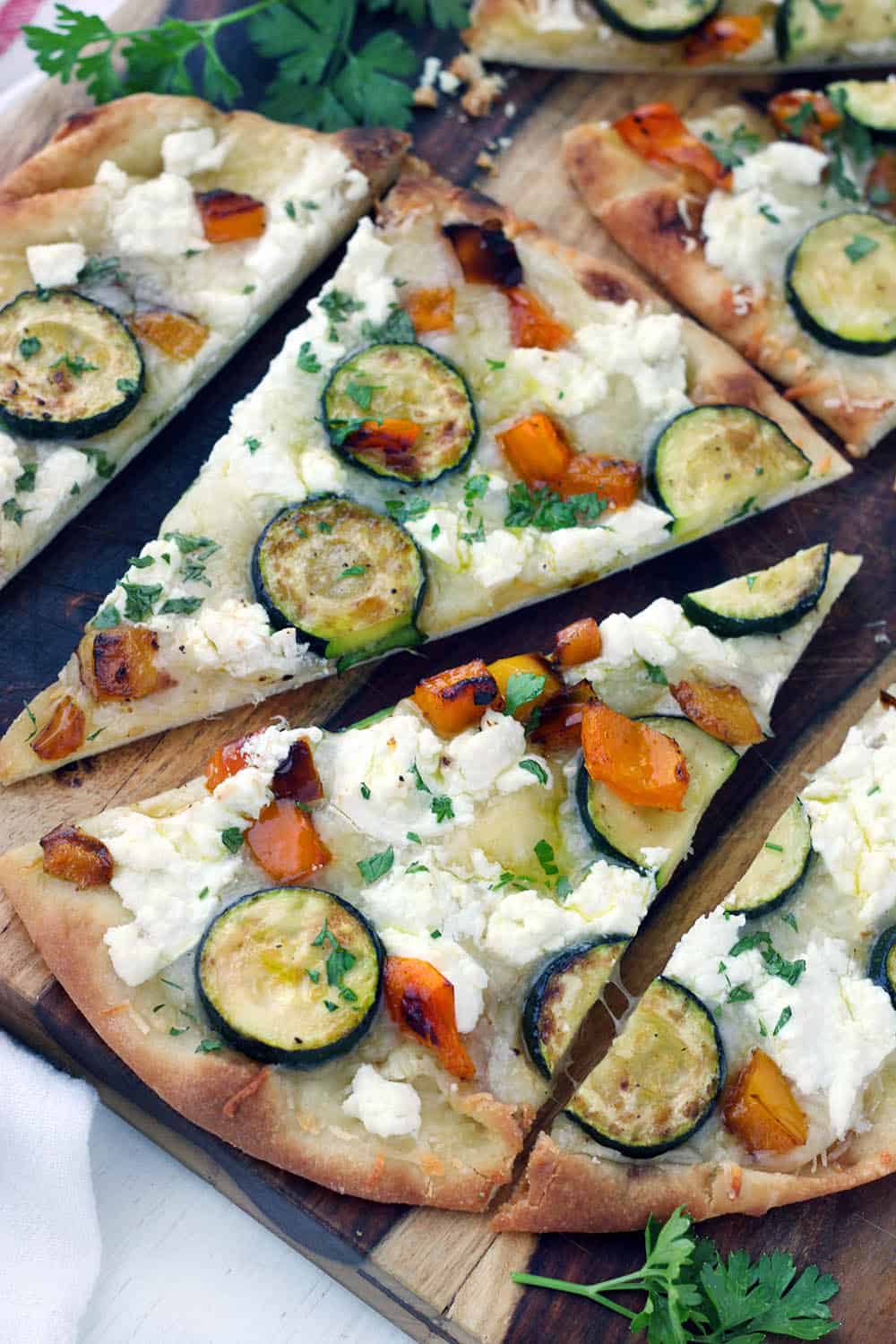 This vegetarian Sautéed Vegetable and Goat Cheese Naan Pizza recipe comes together in only 20 minutes for an easy weeknight dinner! Tip: place the baking rack in the lower half of the oven for a crisp crust.