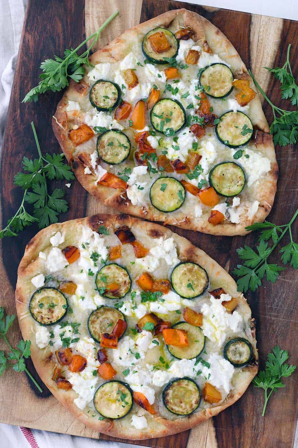 This vegetarian Sautéed Vegetable and Goat Cheese Naan Pizza recipe comes together in only 20 minutes for an easy weeknight dinner! Tip: place the baking rack in the lower half of the oven for a crisp crust.