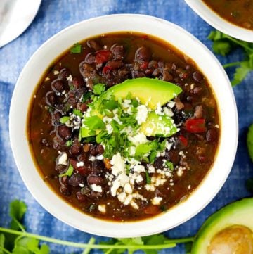 An overhead vertical image of a bowl of black bean soup.