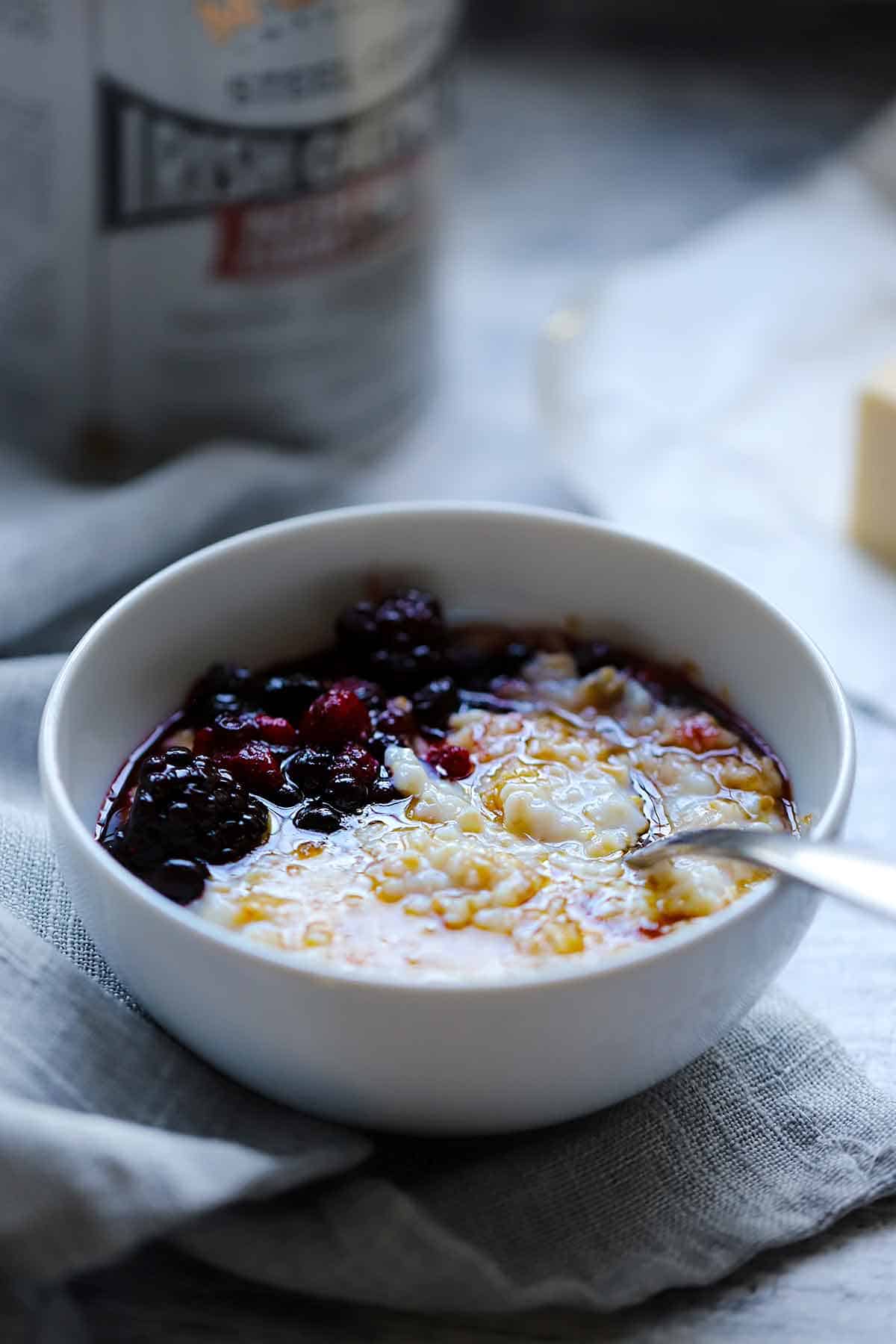 Side view of a bowl of steel cut oatmeal with the can of oats in the background.