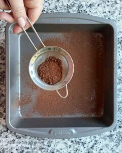Dusting the bottom of a baking pan with cocoa powder the pumpkin pie spice mix.