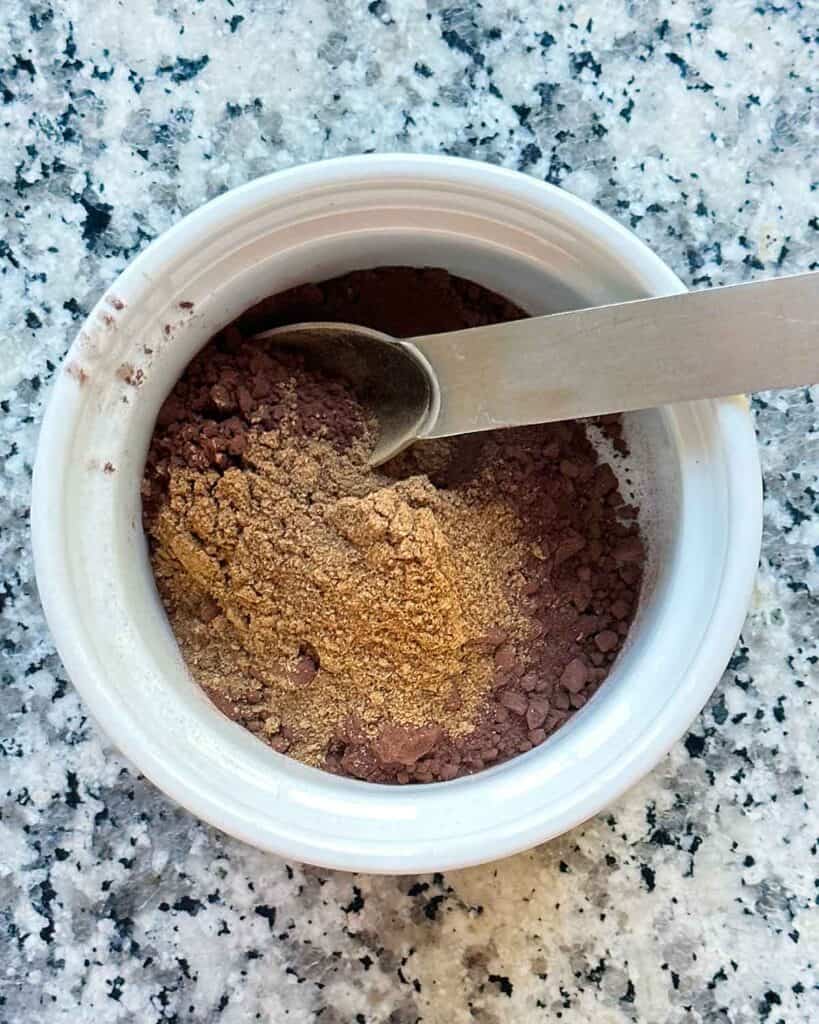 Mixing together cocoa powder and pumpkin pie spice mix.