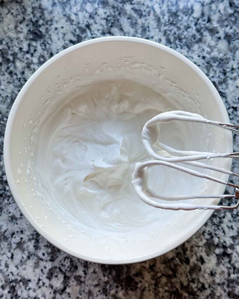 Whipped cream with soft peaks.